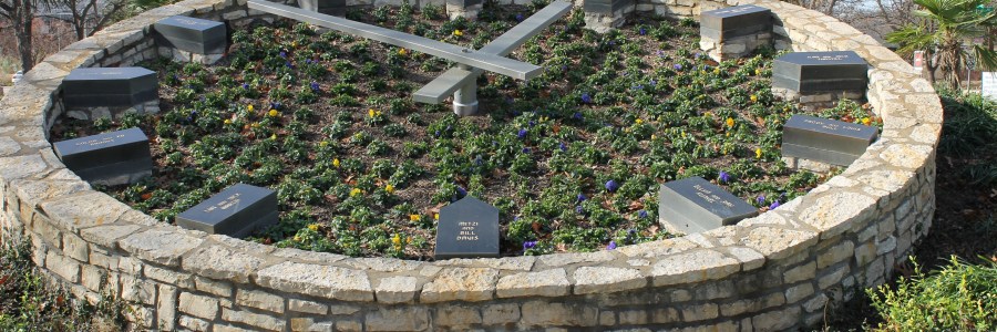 a very large stone clock with metal hands is set in a garden bed tilted toward the viewer