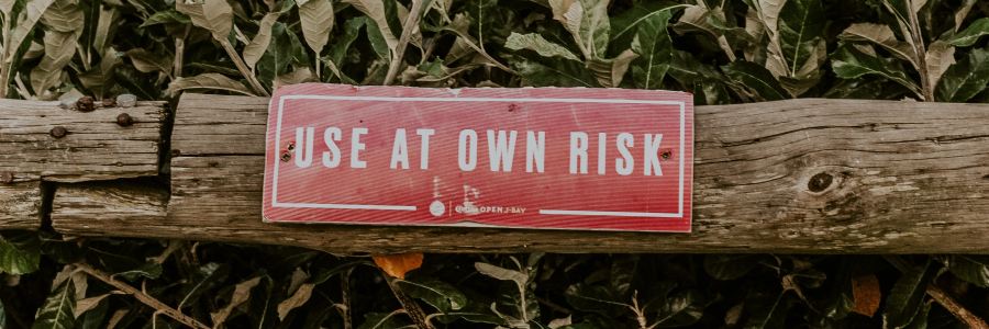 post set among leaves with sign reading use at own risk